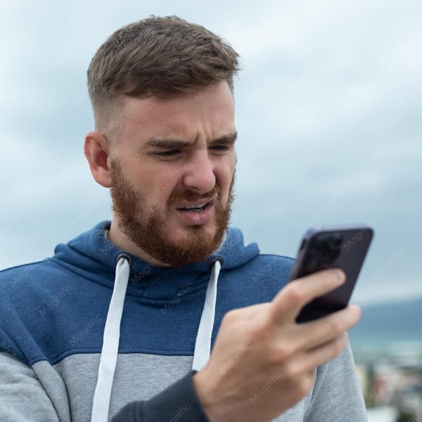 Young person stressed while looking at phone